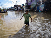 A Nepali man is wading through the flooded water in Nepal on July 31, 2024. (