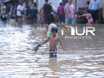 People are wading through the flood in a slum in Kathmandu, Nepal, on July 31, 2024. (