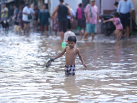 People are wading through the flood in a slum in Kathmandu, Nepal, on July 31, 2024. (