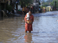 A Nepali woman is wading through the flooded water in Nepal on July 31, 2024. (