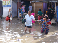 People are wading through the flood in a slum in Kathmandu, Nepal, on July 31, 2024. (