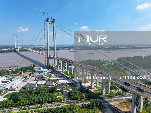 Construction workers are carrying out asphalt paving on the south approach bridge of Longtan Yangtze River Bridge in Nanjing, China, on July...