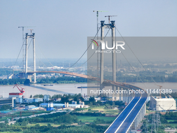 Construction workers are carrying out asphalt paving on the south approach bridge of Longtan Yangtze River Bridge in Nanjing, China, on July...