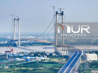 Construction workers are carrying out asphalt paving on the south approach bridge of Longtan Yangtze River Bridge in Nanjing, China, on July...