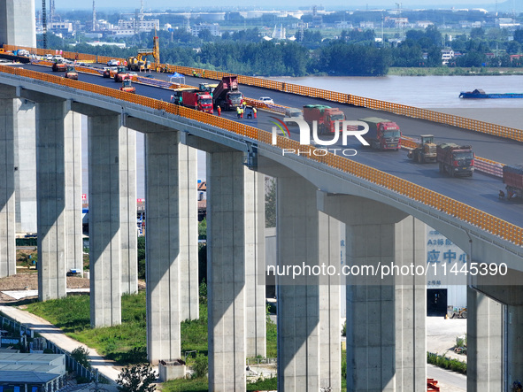 Construction workers are carrying out asphalt paving on the south approach bridge of Longtan Yangtze River Bridge in Nanjing, China, on July...