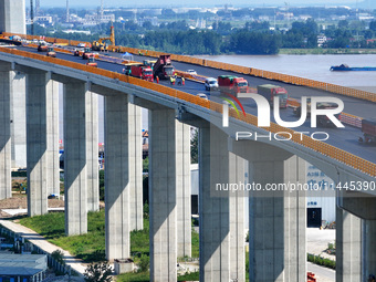 Construction workers are carrying out asphalt paving on the south approach bridge of Longtan Yangtze River Bridge in Nanjing, China, on July...