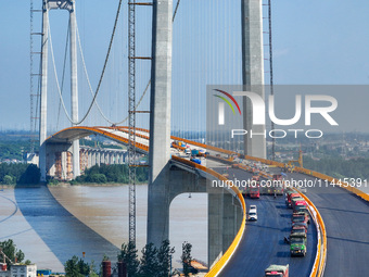 Construction workers are carrying out asphalt paving on the south approach bridge of Longtan Yangtze River Bridge in Nanjing, China, on July...