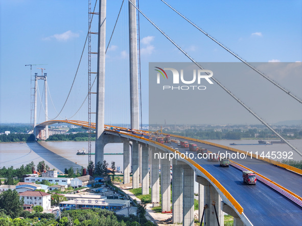 Construction workers are carrying out asphalt paving on the south approach bridge of Longtan Yangtze River Bridge in Nanjing, China, on July...