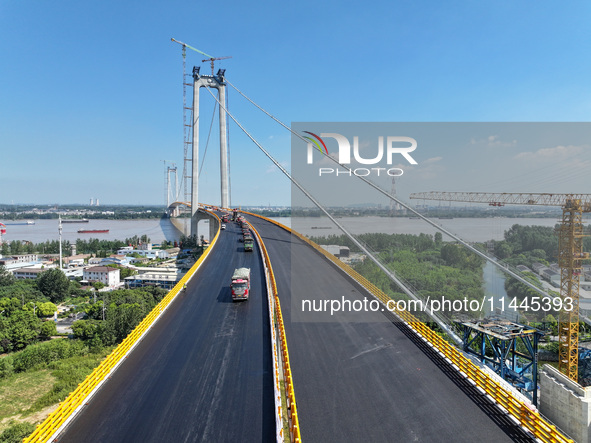 Construction workers are carrying out asphalt paving on the south approach bridge of Longtan Yangtze River Bridge in Nanjing, China, on July...