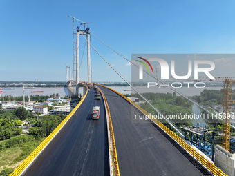 Construction workers are carrying out asphalt paving on the south approach bridge of Longtan Yangtze River Bridge in Nanjing, China, on July...