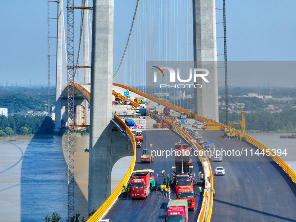 Construction workers are carrying out asphalt paving on the south approach bridge of Longtan Yangtze River Bridge in Nanjing, China, on July...