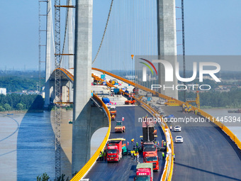 Construction workers are carrying out asphalt paving on the south approach bridge of Longtan Yangtze River Bridge in Nanjing, China, on July...