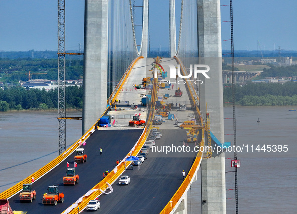 Construction workers are carrying out asphalt paving on the south approach bridge of Longtan Yangtze River Bridge in Nanjing, China, on July...