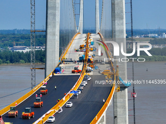 Construction workers are carrying out asphalt paving on the south approach bridge of Longtan Yangtze River Bridge in Nanjing, China, on July...