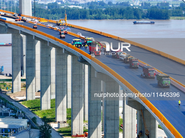 Construction workers are carrying out asphalt paving on the south approach bridge of Longtan Yangtze River Bridge in Nanjing, China, on July...