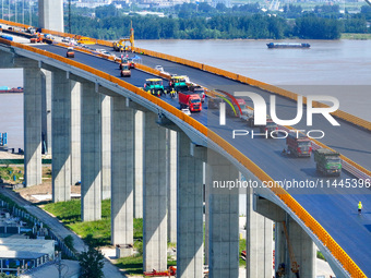 Construction workers are carrying out asphalt paving on the south approach bridge of Longtan Yangtze River Bridge in Nanjing, China, on July...