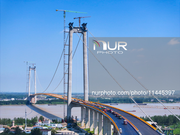 Construction workers are carrying out asphalt paving on the south approach bridge of Longtan Yangtze River Bridge in Nanjing, China, on July...