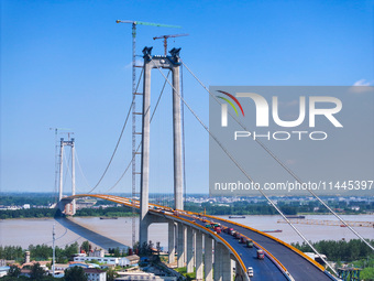 Construction workers are carrying out asphalt paving on the south approach bridge of Longtan Yangtze River Bridge in Nanjing, China, on July...