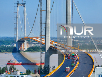 Construction workers are carrying out asphalt paving on the south approach bridge of Longtan Yangtze River Bridge in Nanjing, China, on July...