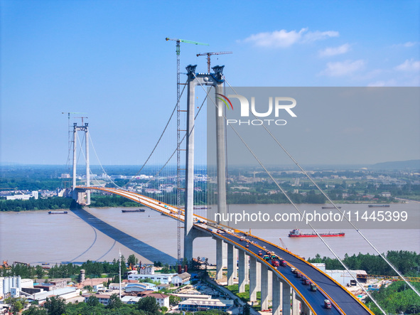 Construction workers are carrying out asphalt paving on the south approach bridge of Longtan Yangtze River Bridge in Nanjing, China, on July...