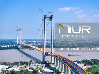 Construction workers are carrying out asphalt paving on the south approach bridge of Longtan Yangtze River Bridge in Nanjing, China, on July...