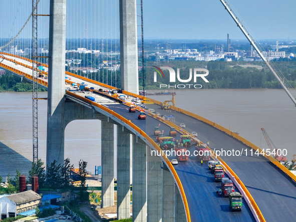 Construction workers are carrying out asphalt paving on the south approach bridge of Longtan Yangtze River Bridge in Nanjing, China, on July...