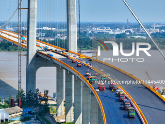 Construction workers are carrying out asphalt paving on the south approach bridge of Longtan Yangtze River Bridge in Nanjing, China, on July...