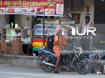 A Sadhu is chatting with a man outside a dhaba (roadside restaurant) in Jaspur, Uttarakhand, India, on April 19, 2024. (