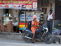 A Sadhu is chatting with a man outside a dhaba (roadside restaurant) in Jaspur, Uttarakhand, India, on April 19, 2024. (