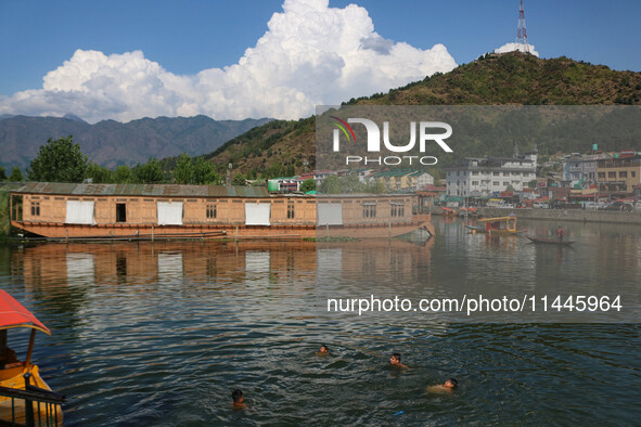 Children are taking a bath in Dal Lake on a hot summer day in Srinagar, Jammu and Kashmir, on July 31, 2024. 