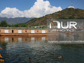 Children are taking a bath in Dal Lake on a hot summer day in Srinagar, Jammu and Kashmir, on July 31, 2024. (