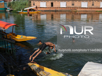 A child is jumping into the waters of Dal Lake on a hot summer day in Srinagar, Jammu and Kashmir, on July 31, 2024. (