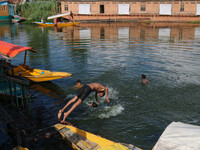 A child is jumping into the waters of Dal Lake on a hot summer day in Srinagar, Jammu and Kashmir, on July 31, 2024. (