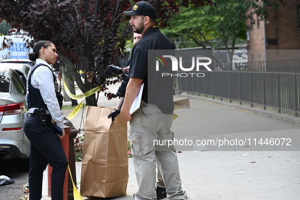 Crime scene investigators from the New York City Police Department are bringing out evidence and evidence markers as they are investigating...