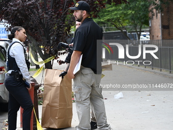 Crime scene investigators from the New York City Police Department are bringing out evidence and evidence markers as they are investigating...