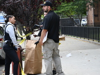 Crime scene investigators from the New York City Police Department are bringing out evidence and evidence markers as they are investigating...