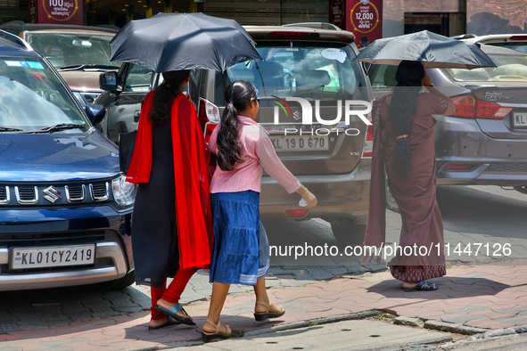 Women are using umbrellas to protect themselves from the hot sun in Thiruvananthapuram (Trivandrum), Kerala, India, on April 13, 2024. 