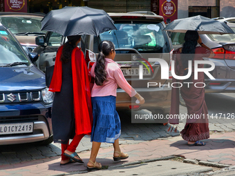 Women are using umbrellas to protect themselves from the hot sun in Thiruvananthapuram (Trivandrum), Kerala, India, on April 13, 2024. (