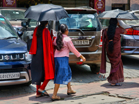 Women are using umbrellas to protect themselves from the hot sun in Thiruvananthapuram (Trivandrum), Kerala, India, on April 13, 2024. (