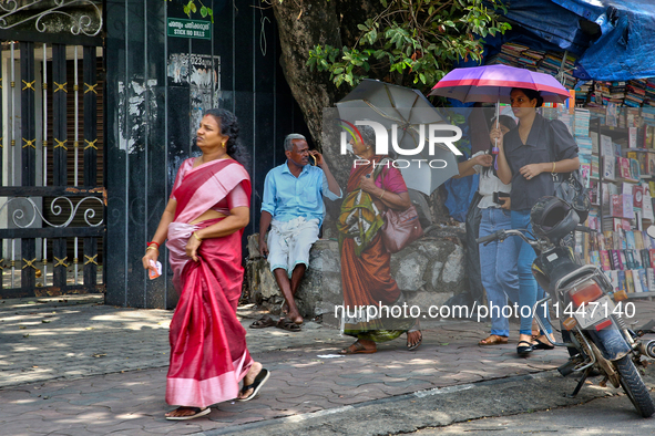 A woman is using an umbrella to protect herself from the hot sun in Thiruvananthapuram (Trivandrum), Kerala, India, on April 13, 2024. 