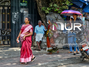 A woman is using an umbrella to protect herself from the hot sun in Thiruvananthapuram (Trivandrum), Kerala, India, on April 13, 2024. (