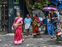 A woman is using an umbrella to protect herself from the hot sun in Thiruvananthapuram (Trivandrum), Kerala, India, on April 13, 2024. (