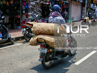 A man is carrying sacks filled with potatoes on his motorbike in Thiruvananthapuram (Trivandrum), Kerala, India, on April 13, 2024. (