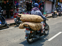 A man is carrying sacks filled with potatoes on his motorbike in Thiruvananthapuram (Trivandrum), Kerala, India, on April 13, 2024. (