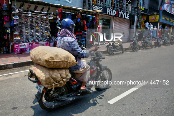 A man is carrying sacks filled with potatoes on his motorbike in Thiruvananthapuram (Trivandrum), Kerala, India, on April 13, 2024. 