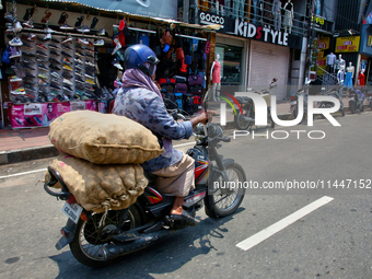 A man is carrying sacks filled with potatoes on his motorbike in Thiruvananthapuram (Trivandrum), Kerala, India, on April 13, 2024. (