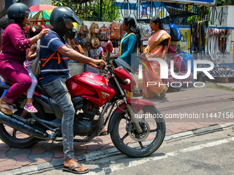 A family is riding a motorbike in Thiruvananthapuram (Trivandrum), Kerala, India, on April 13, 2024. (