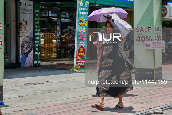 A woman is using a bag to protect herself from the hot sun in Thiruvananthapuram (Trivandrum), Kerala, India, on April 13, 2024. 