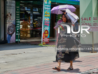 A woman is using a bag to protect herself from the hot sun in Thiruvananthapuram (Trivandrum), Kerala, India, on April 13, 2024. (