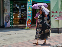 A woman is using a bag to protect herself from the hot sun in Thiruvananthapuram (Trivandrum), Kerala, India, on April 13, 2024. (